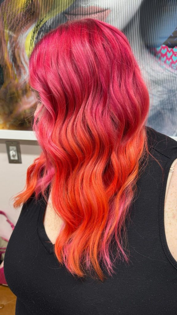 sunset ombre hair color with pink roots blending into orange waves Oklahoma City salon