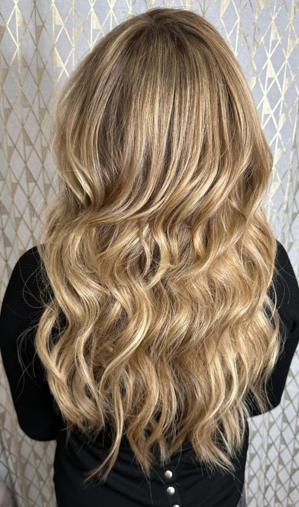Natural Beaded Row extensions with dimensional blonde color and soft, flowing waves