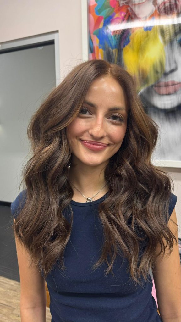 Natural Beaded Row hair extensions on brunette hair with soft waves and blended highlights